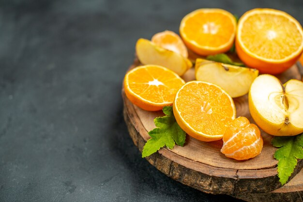 Top view cut oranges and apples cut orange on dark surface