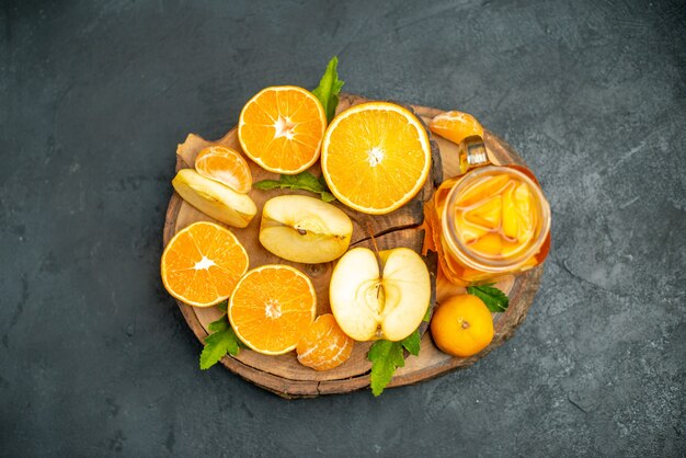 Top view cut oranges and apples cut orange on dark surface