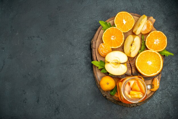 Top view cut oranges and apples cut orange on dark surface