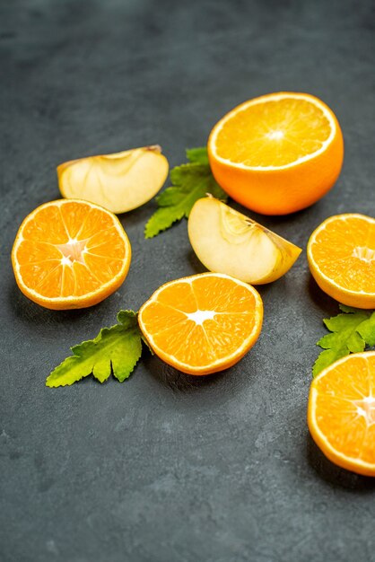 Top view cut oranges and apples on dark background