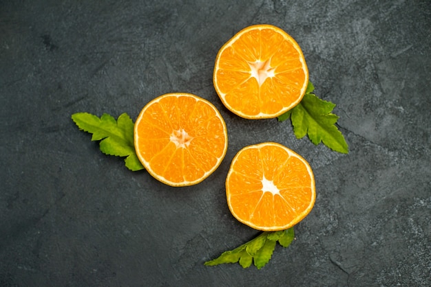 Free photo top view cut oranges on dark background