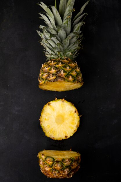 Top view of cut pineapple on black surface