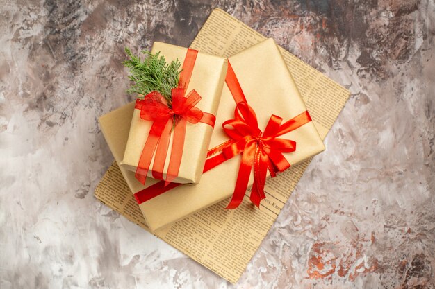 Top view cute christmas presents tied with red bows on a light background