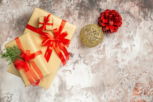 Top view cute christmas presents tied with red bows on light background