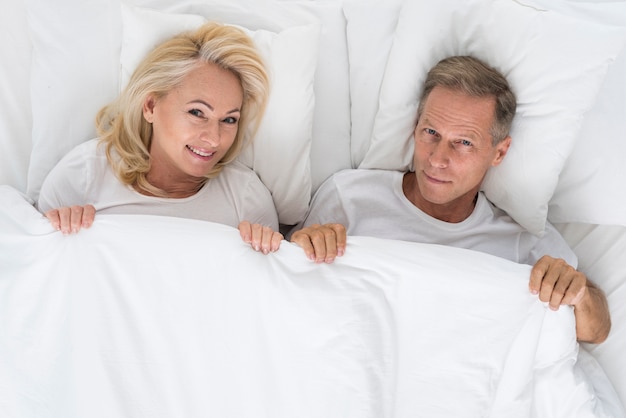 Top view cute couple sitting in bed