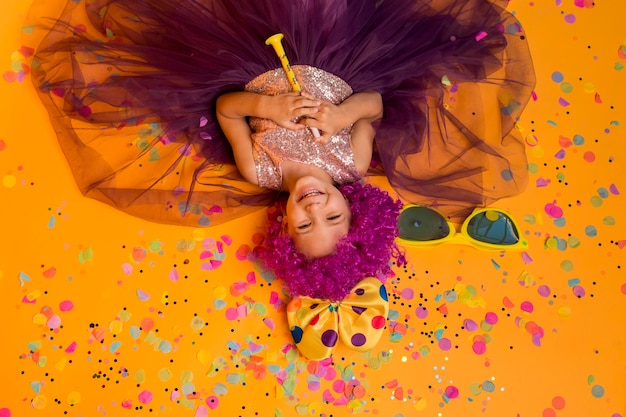 Top view of cute girl with clown wig and confetti