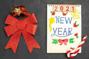 Free photo top view cute red bow with new year written notepad