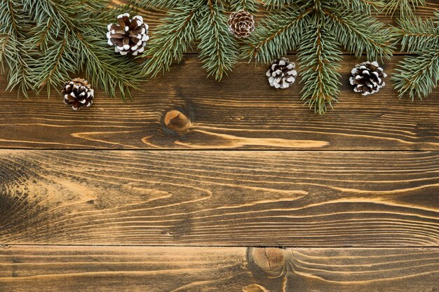 Top view cute winter pine needles on wooden background