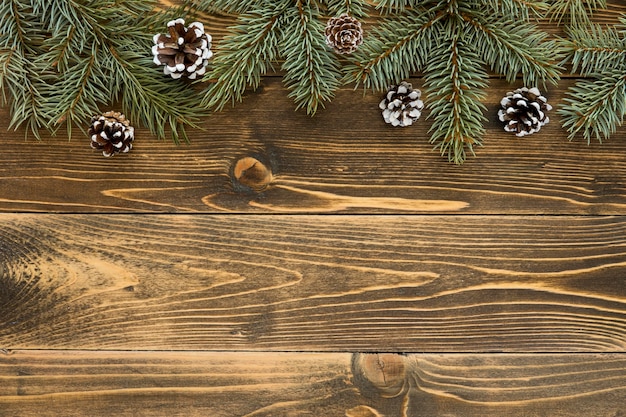 Top view cute winter pine needles on wooden background