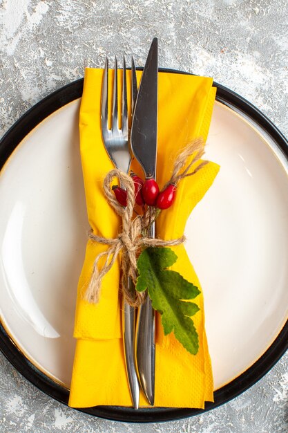 Top view of cutlery set with yellow napkin for meal on ice surface