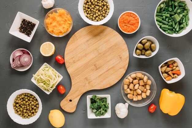 Top view of cutting board with hot peppers and green peas