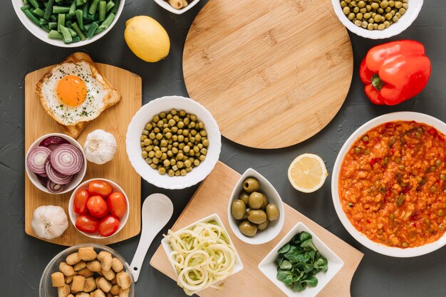 Top view of cutting boards with fried egg and olives