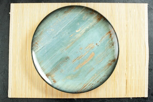 Top view cyan round platter beige board on black table