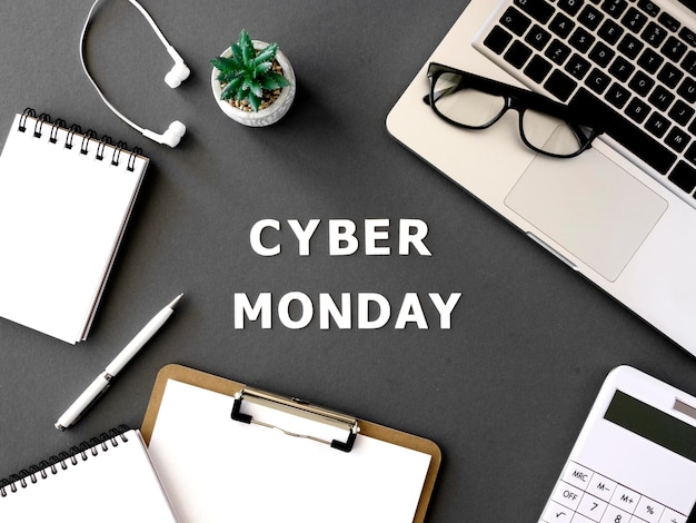 Вид сверху ноутбука cyber monday с наушниками и блокнотом