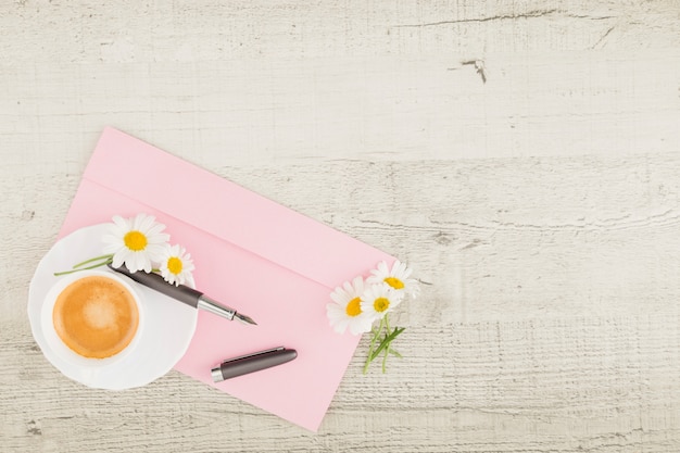 Top view daisies and coffee on wooden background