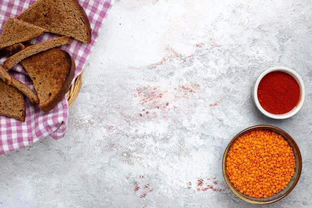 Top view dark bread loafs with orange raw beans on white backgrond bread bun copybook food