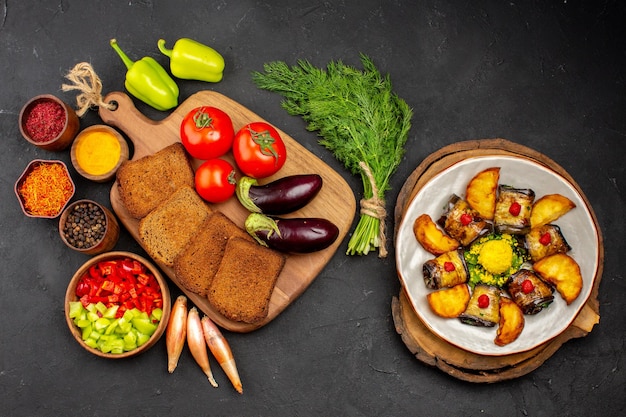 Top view dark bread loafs with seasonings tomatoes and eggplants on a dark background salad health ripe meal