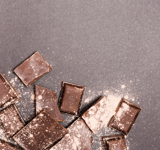 Вид сверху темного шоколада в какао-порошке