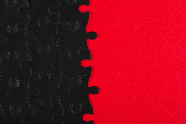 Top view dark puzzle pieces and red background