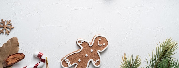 Top view of decorated christmas gingerbread cookies with decorations on white table background with copy space, concept of holiday celebration.