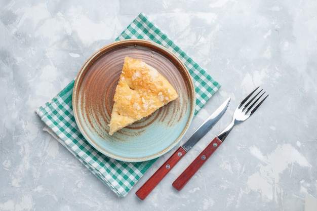 Вид сверху вкусный яблочный пирог, нарезанный внутри тарелки на белом столе, пирог, пирог, сладкая выпечка, бисквит