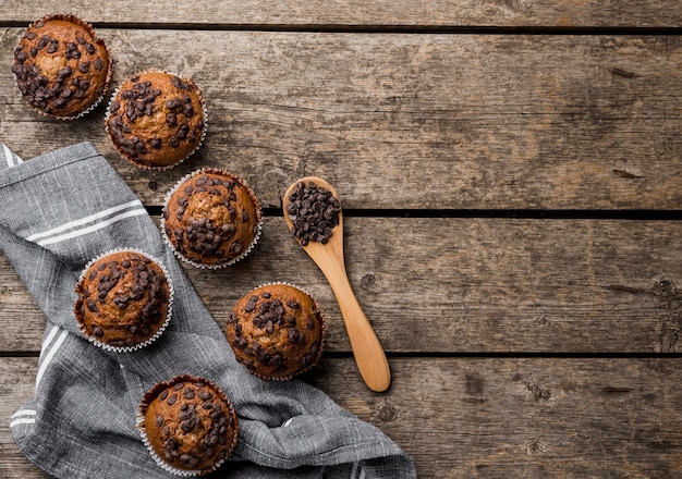 Free photo top view delicious arrangement of muffins on wooden background