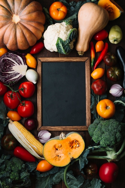 Top view delicious arrangement of veggies with chalkboard