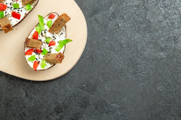 회색 표면에 사워 크림 슬라이스 고추와 빵 조각과 함께 맛있는 아보카도 식사의 상위 뷰