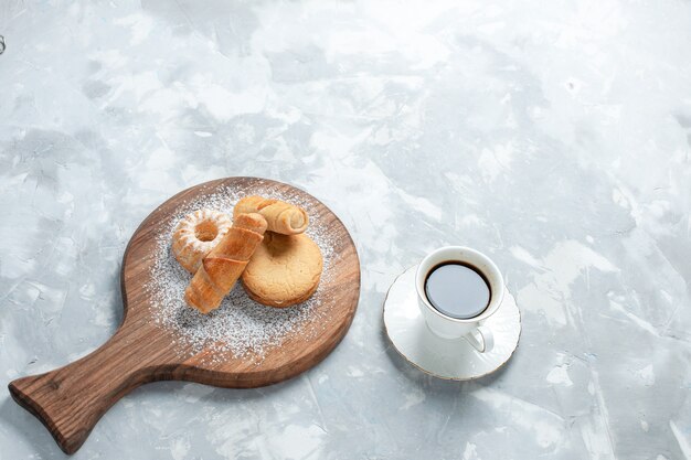 Top view delicious bagels with cakes on light white background.