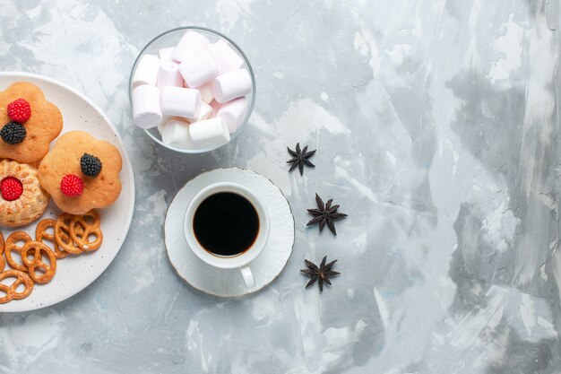 Top view delicious bagels with cookies crackers and cakes with tea on light white desk.