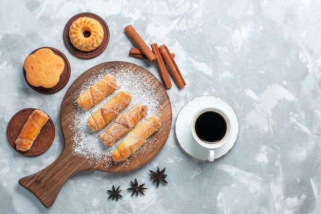 明るい白の背景に小さなケーキ茶とクッキーとトップビューのおいしいベーグル。