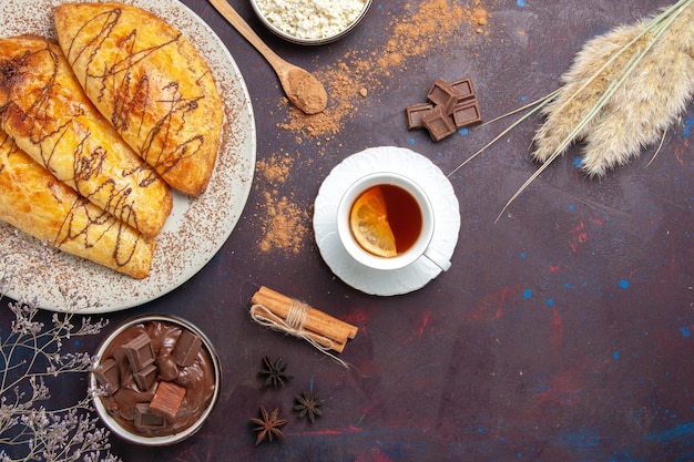 Vista dall'alto deliziosi pasticcini al forno con ricotta e tè nello spazio buio