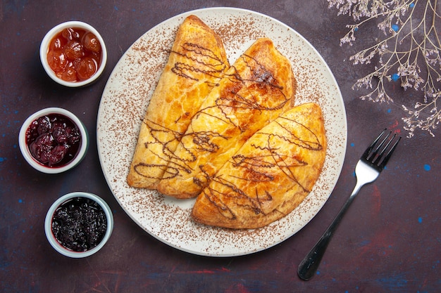 Free photo top view delicious baked pastries with jam on a dark space