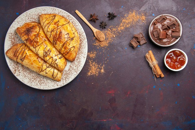 Top view delicious baked pastries with jam on dark space