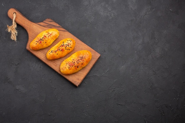 Top view delicious baked patties fresh off the oven on a dark background pie pastry dough oven meat cake bake