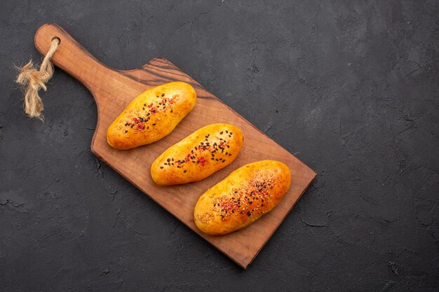 Top view delicious baked patties fresh off the oven on dark background pie pastry dough oven meat cake bake