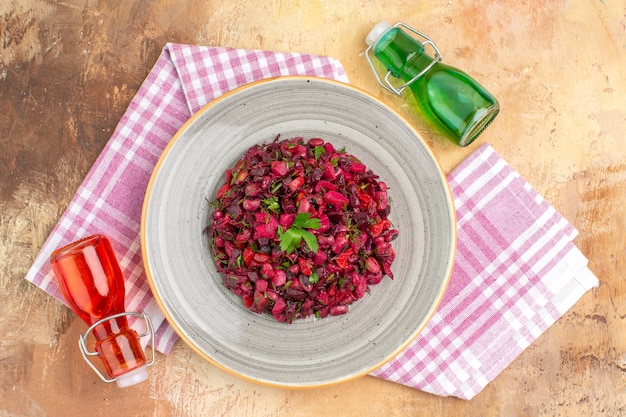 Top view delicious beet salad on a ceramic plate dressed in olive oil on a wooden table with copy space