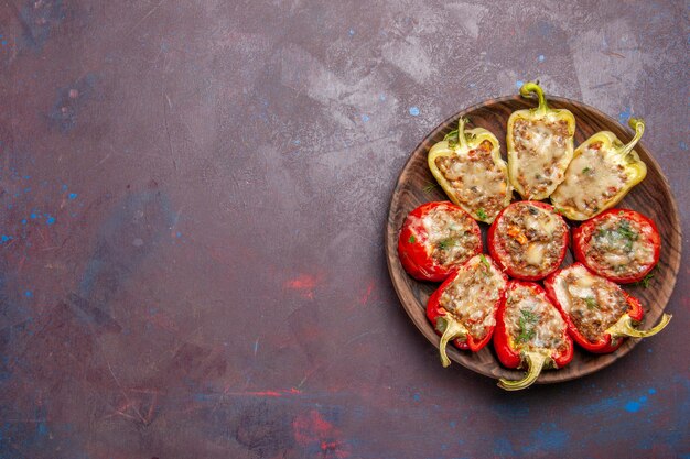 Top view delicious bell-peppers tasty cooked dish with meat on dark desk dinner dish meat bake food salt