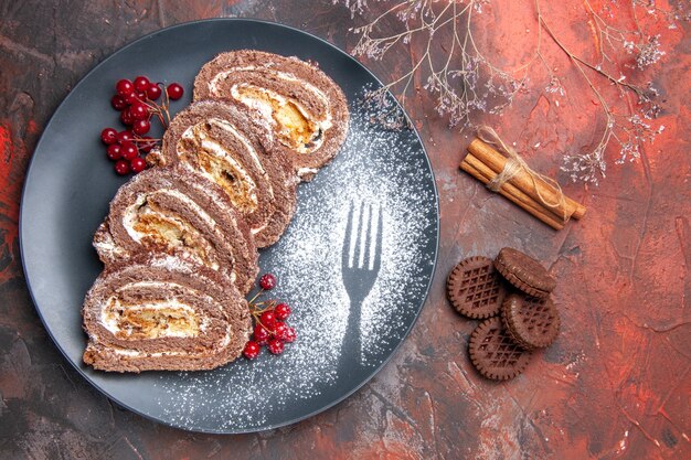 Top view of delicious biscuit rolls with cookies on dark surface