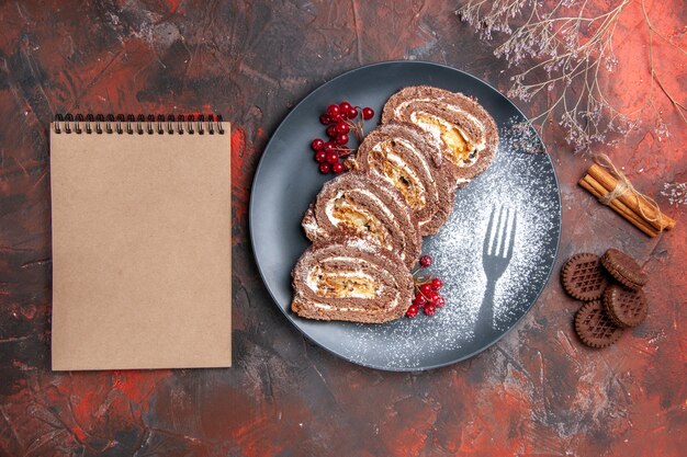 Top view of delicious biscuit rolls with cookies on dark surface