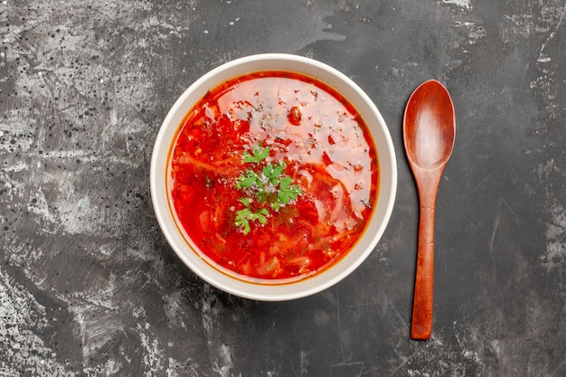 Top view of delicious borsch red vegetable soup on dark surface