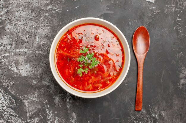 Вид сверху вкусного борща красный овощной суп на темной поверхности