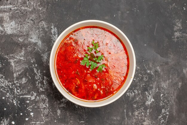 Вид сверху вкусного борща красный овощной суп на темной поверхности