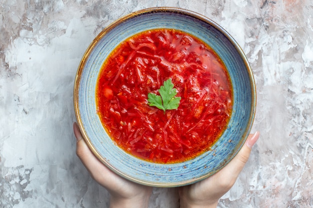 흰색 배경에 있는 접시 안에 있는 맛있는 보르쉬 우크라이나 비트 수프