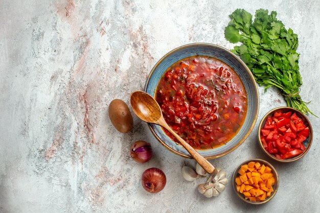 Top view delicious borsch ukranian beet soup with greens on white space