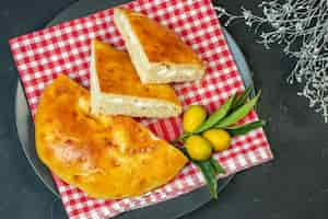 Foto gratuita vista dall'alto di deliziosi kumquat di pane con gambo su superficie scura