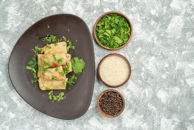 Top view delicious cabbage dolma consists of ground meat with
greens on white background dinner pepper food dish meat