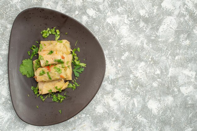 Top view delicious cabbage dolma consists of ground meat with greens on the white background meat dinner calorie oil dish food