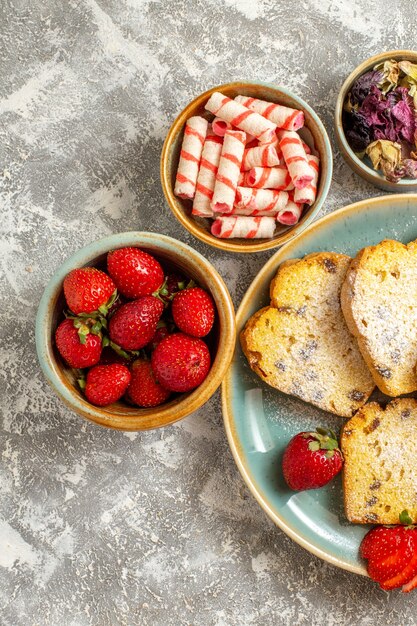 Top view delicious cake slices with fruits on light surface fruit cake sweet pie