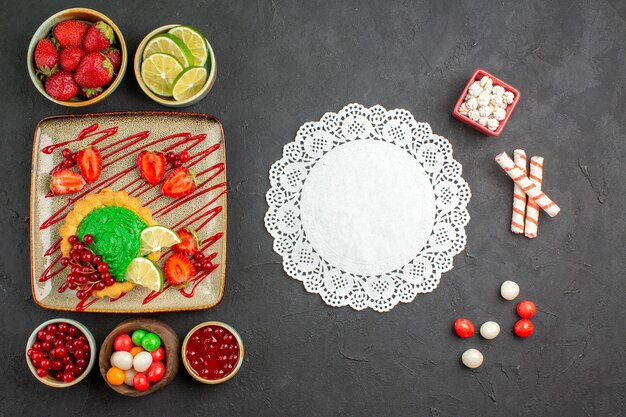 Top view delicious cake with candies and fruits